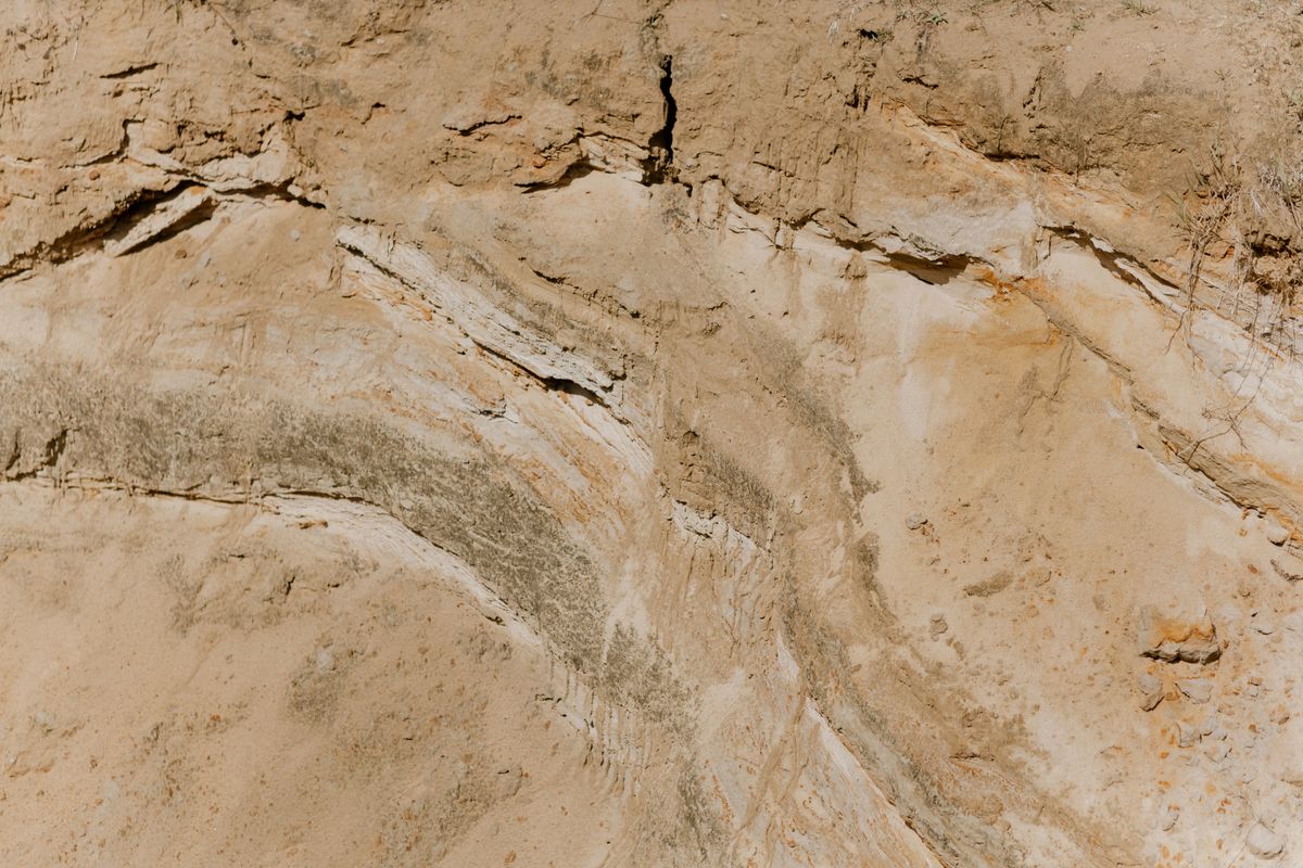 Cross-section of geological soil and sand layers revealing underground ground conditions.