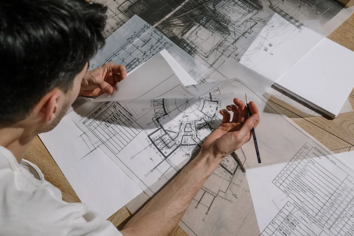 Engineer reviewing architectural blueprints and project feasibility plans